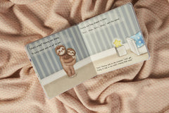 Inside on of the pages of the book, with one sloth holding another.