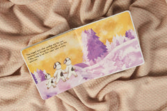 Inside the book, three cows holding hands walking through a purple field.